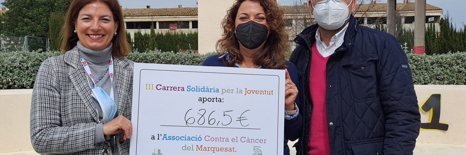 La directora de la EFA Torrealedua, acompañada por el aclcade de Llombai entregan el cheque a AECC